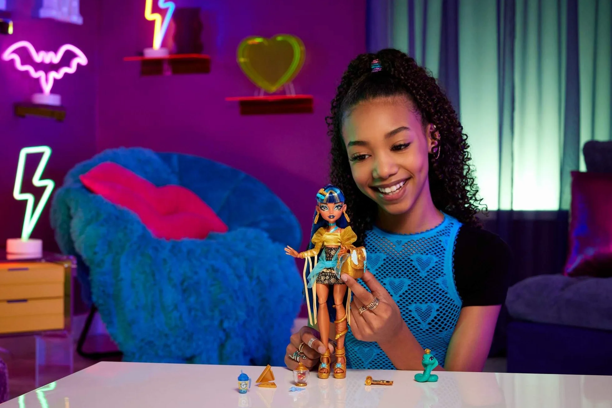 Monster High Cleo De Nile Lalka w złocistej bluzce i spódniczce z hieroglifami, kobra Hissette i akcesoria, takie jak plecak, „przekąska” i „papirus”, HXH74