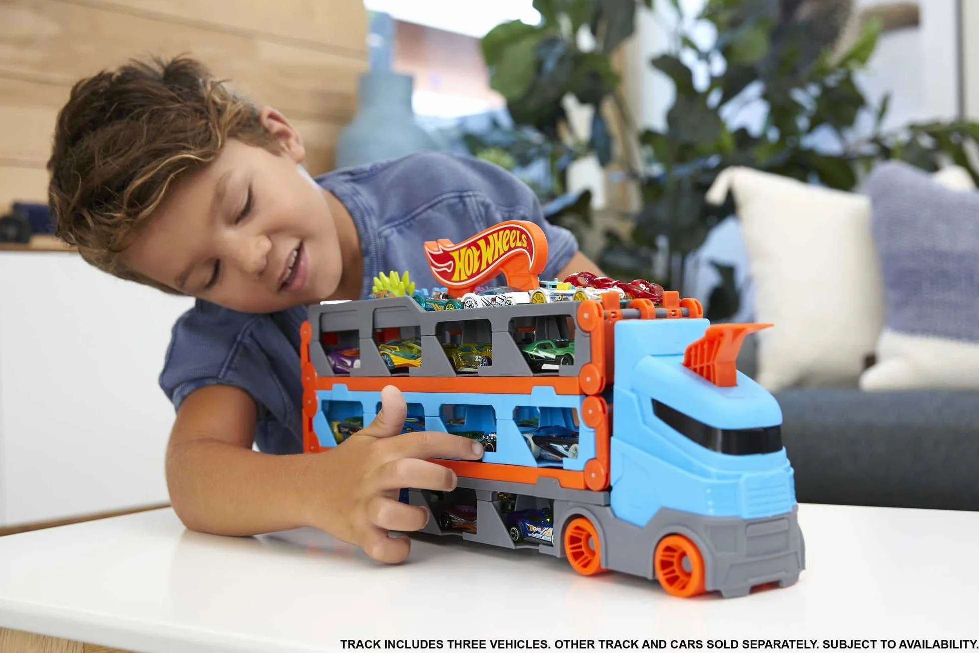 Hot Wheels - Wyścigowy transporter 2w1 z 3 samochodzikami w skali 1:64 i rozkładanym torem wyścigowym o długości 1,8 m oraz miejscem na 20 pojazdów; dla dzieci w wieku od 4 do 8 lat, HGH33