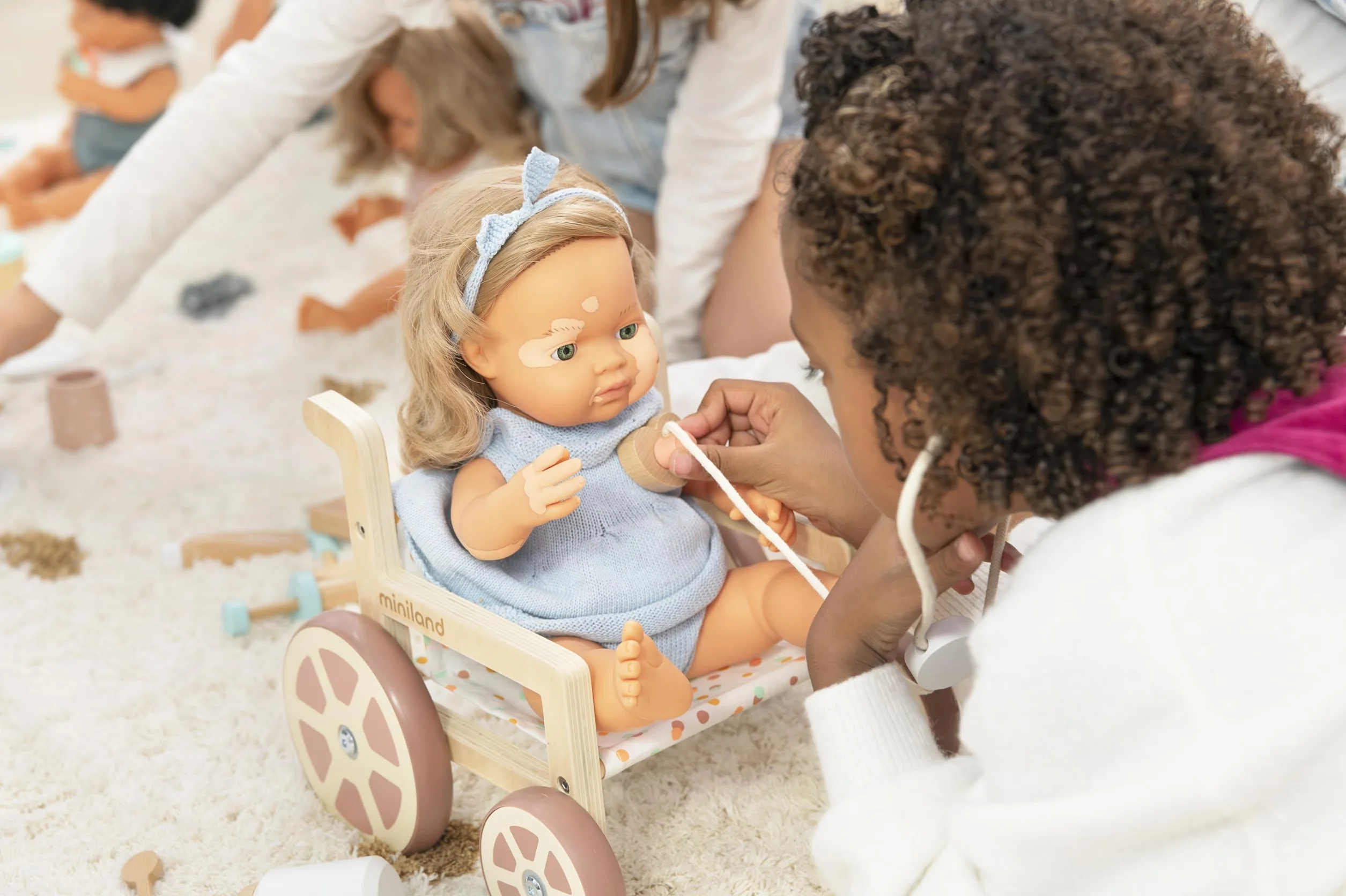 Miniland Wózek inwalidzki z materiałów przyjaznych dla środowiska dla lalek do 38 cm. Włączenie.